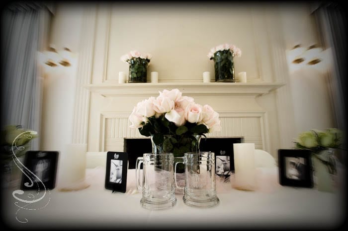 Roses in mason jars and wedding photos of Renee and Tom's parents decorated their table at the reception inside the Ranch House.