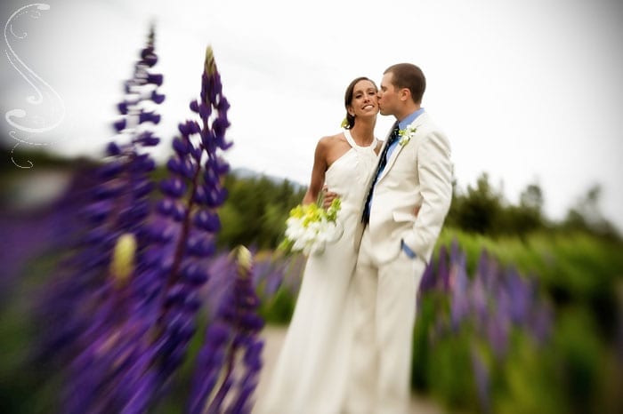 This "lens baby" portrait adds a unique element to the image with the wild lupine blurring from the foreground.