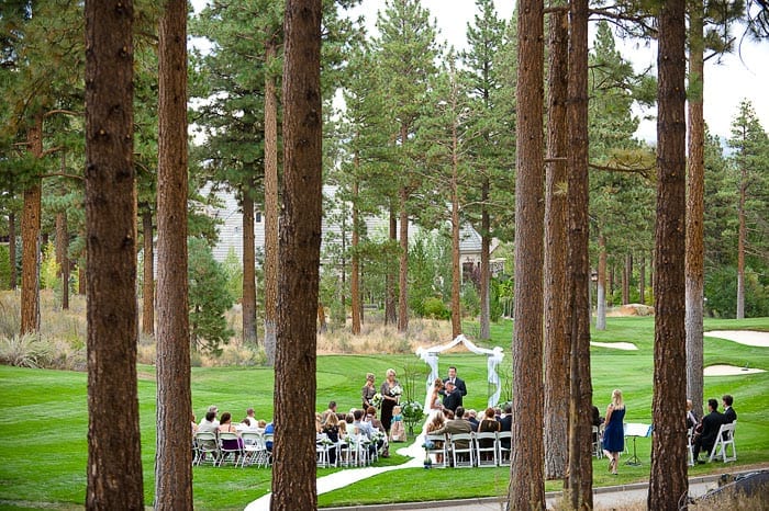 The wedding ceremony among the trees of the practice green.