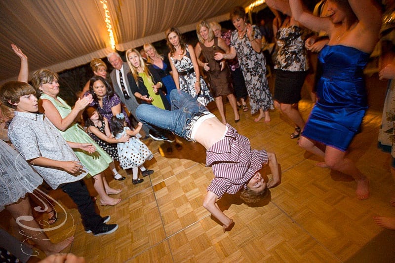 Lots of kids having a great time and getting acrobatic during the wedding reception