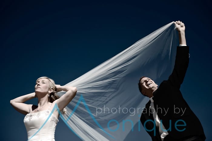 Bride and groom playing with veil