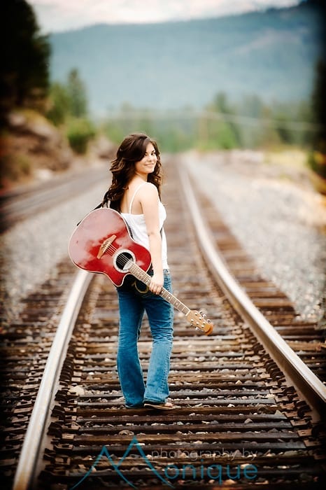 senior portrait on train tracks with guitar