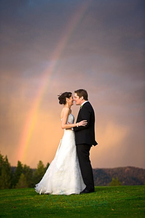 vertical bride and groom with rainbow