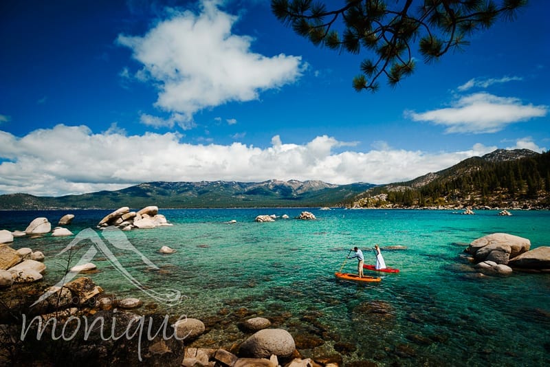 bride and groom on paddle boards in sand harbor, lake tahoe