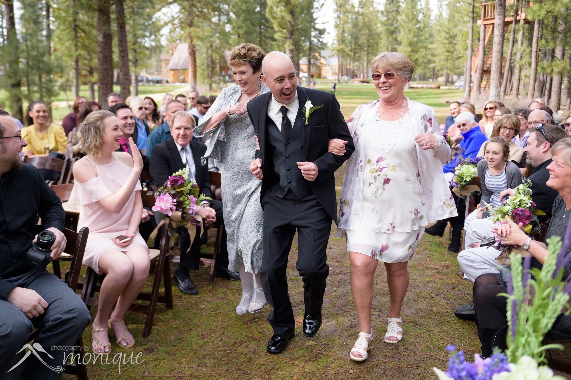 groom dancing down aisle with parents