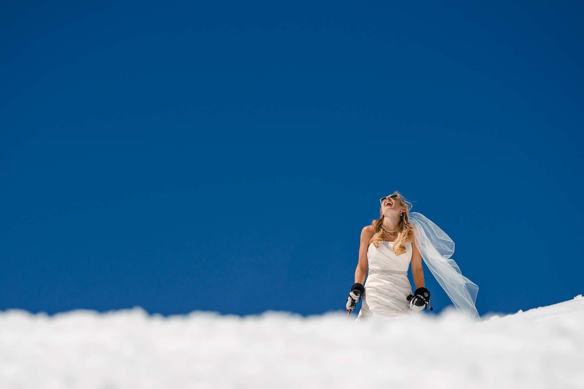 Photograph of skiing bride during a spring ski day at Palisades Tahoe Ski Resort wedding near Lake Tahoe, California. Photography by Monique, Lake Tahoe wedding photographer.