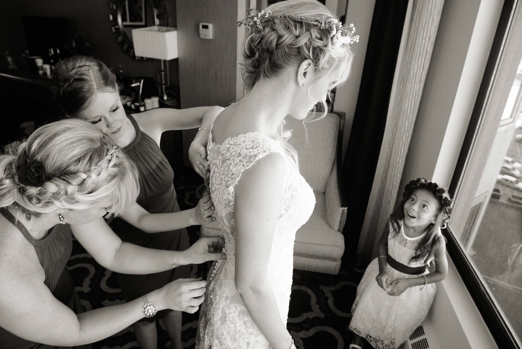 Flower girl with amazing expression looks up at bride getting ready for her wedding at Edgewood Golf and Country Club in South Lake Tahoe, Nevada.