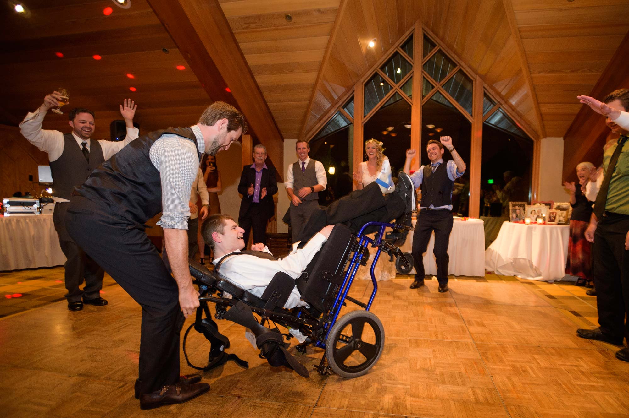 Groomsment dancing with brides brother in a wheelchair at Lake Tahoe Edgewood wedding. Lake Tahoe wedding photography by Photography by Monique in Reno, Nevada.