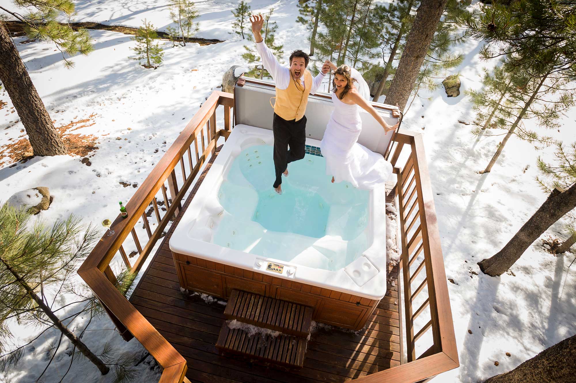 Fun Lake Tahoe wedding photograph of bride and groom jumping into hot tub