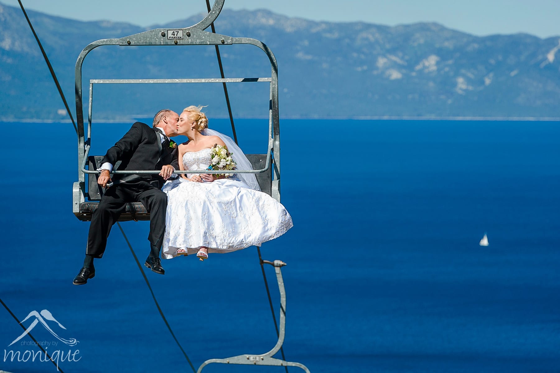 Homewood Mountain Ski Resort wedding photography by Photography by Monique on top of the mountain with Lake Tahoe in the background and the bride and her father riding the chair lift