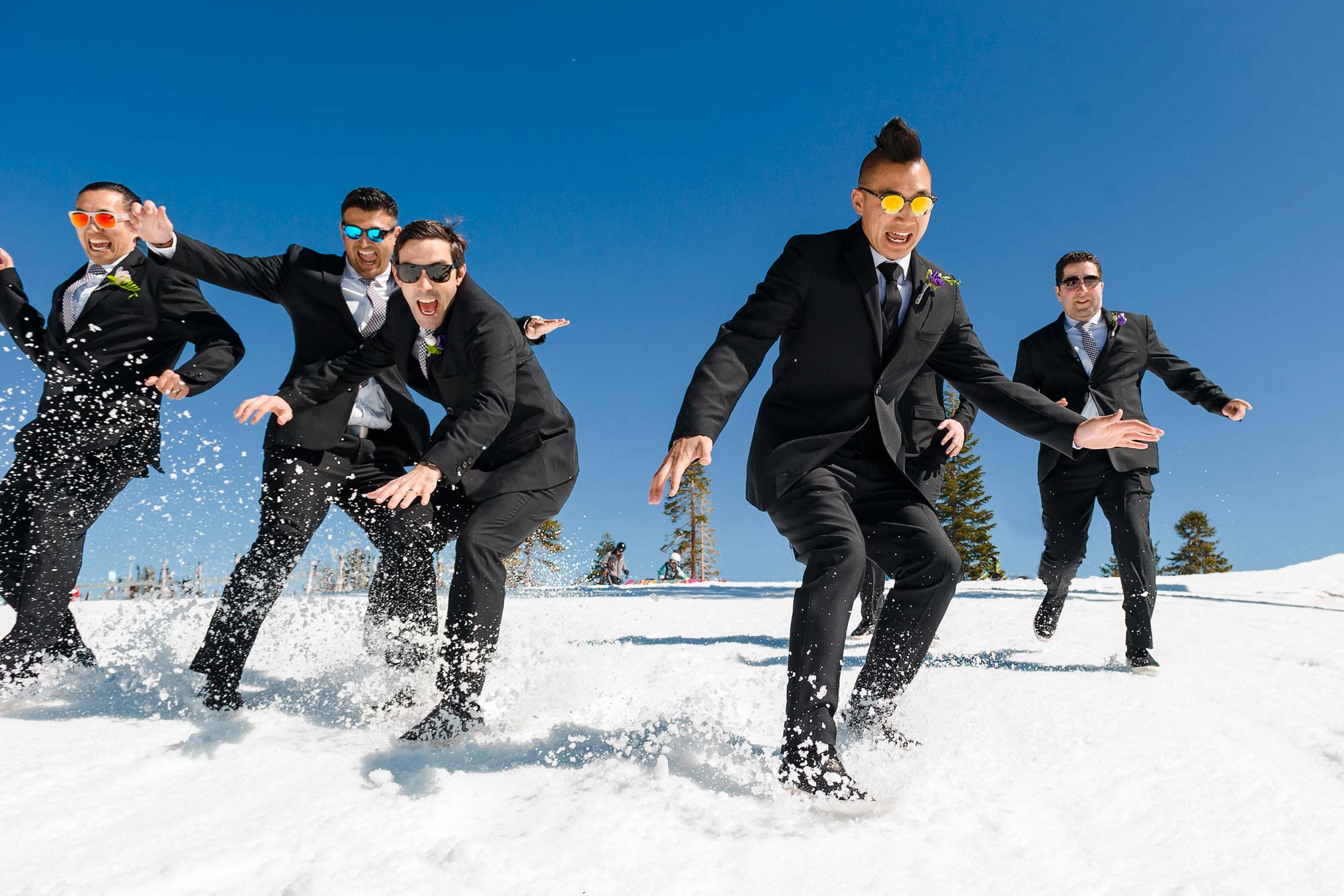 groomsmen sliding through the snow at Northstar wedding