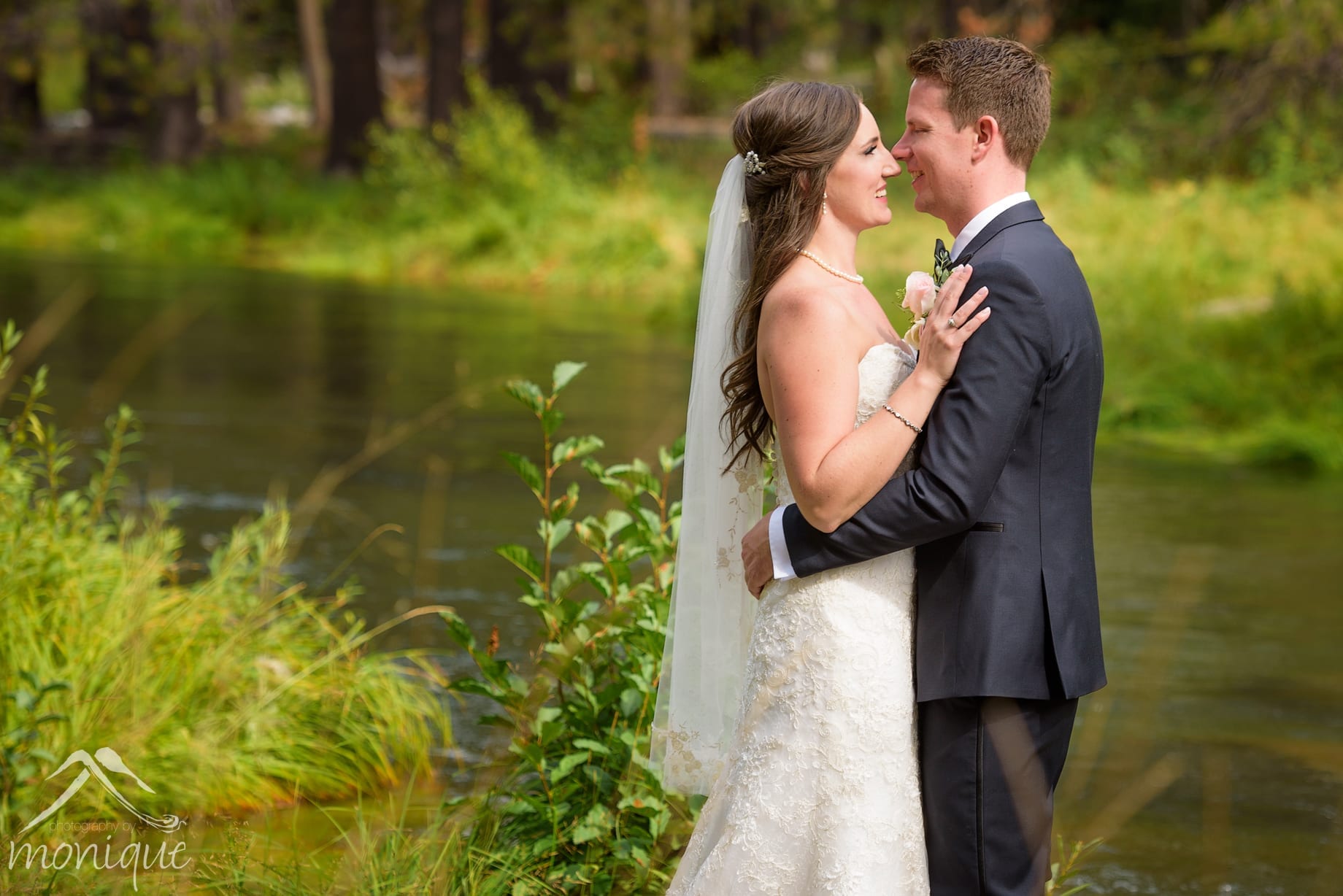 The Lodge at Tahoe Donner wedding photography with a bride and groom next to a small creek during their first look portrait session by Photography by Monique specializing in documentary style wedding photojournalism