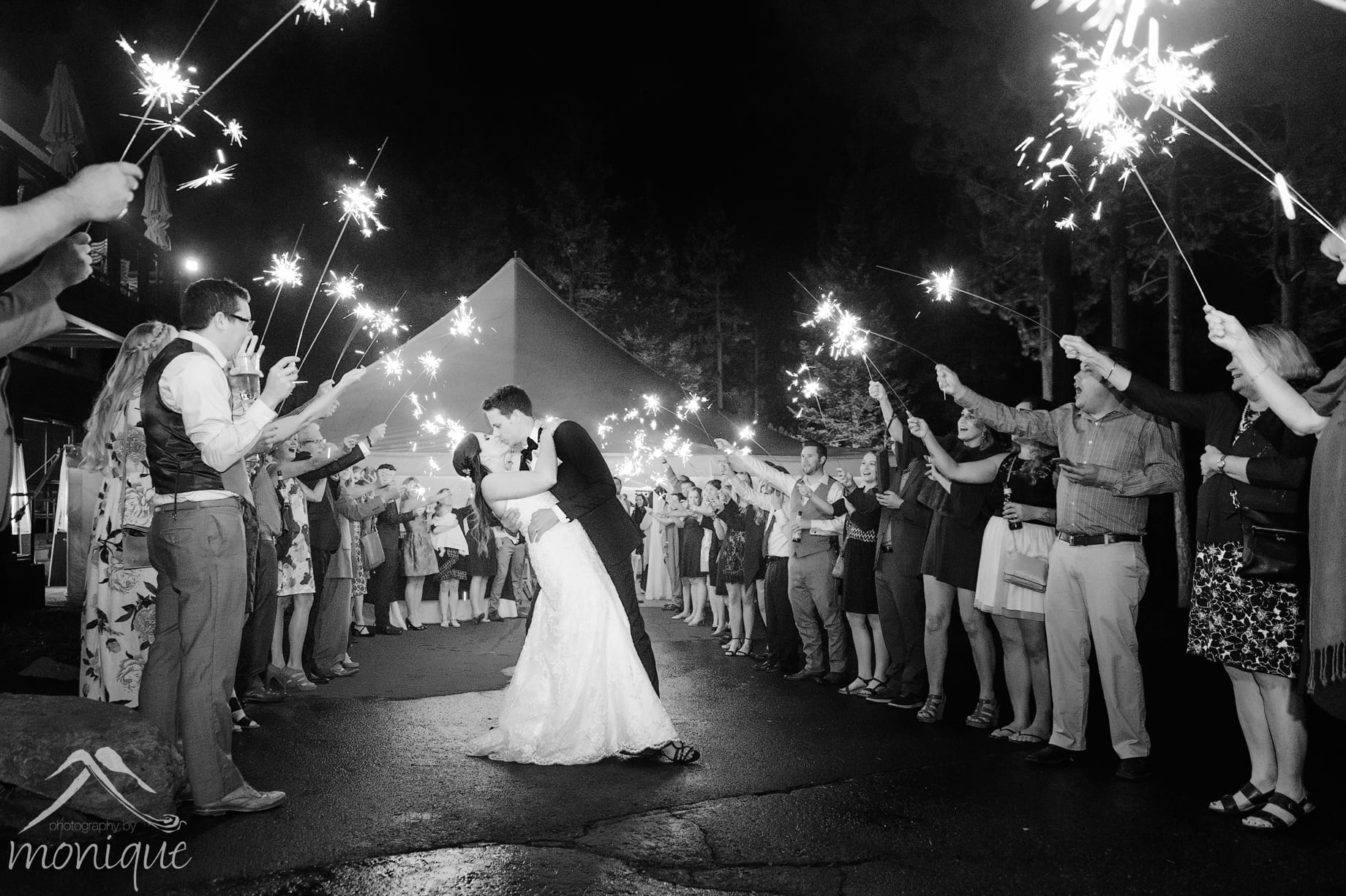 The Lodge at Tahoe Donner wedding photography with a bride and groom kissing during a sparkler exit by Photography by Monique specializing in documentary style wedding photojournalism