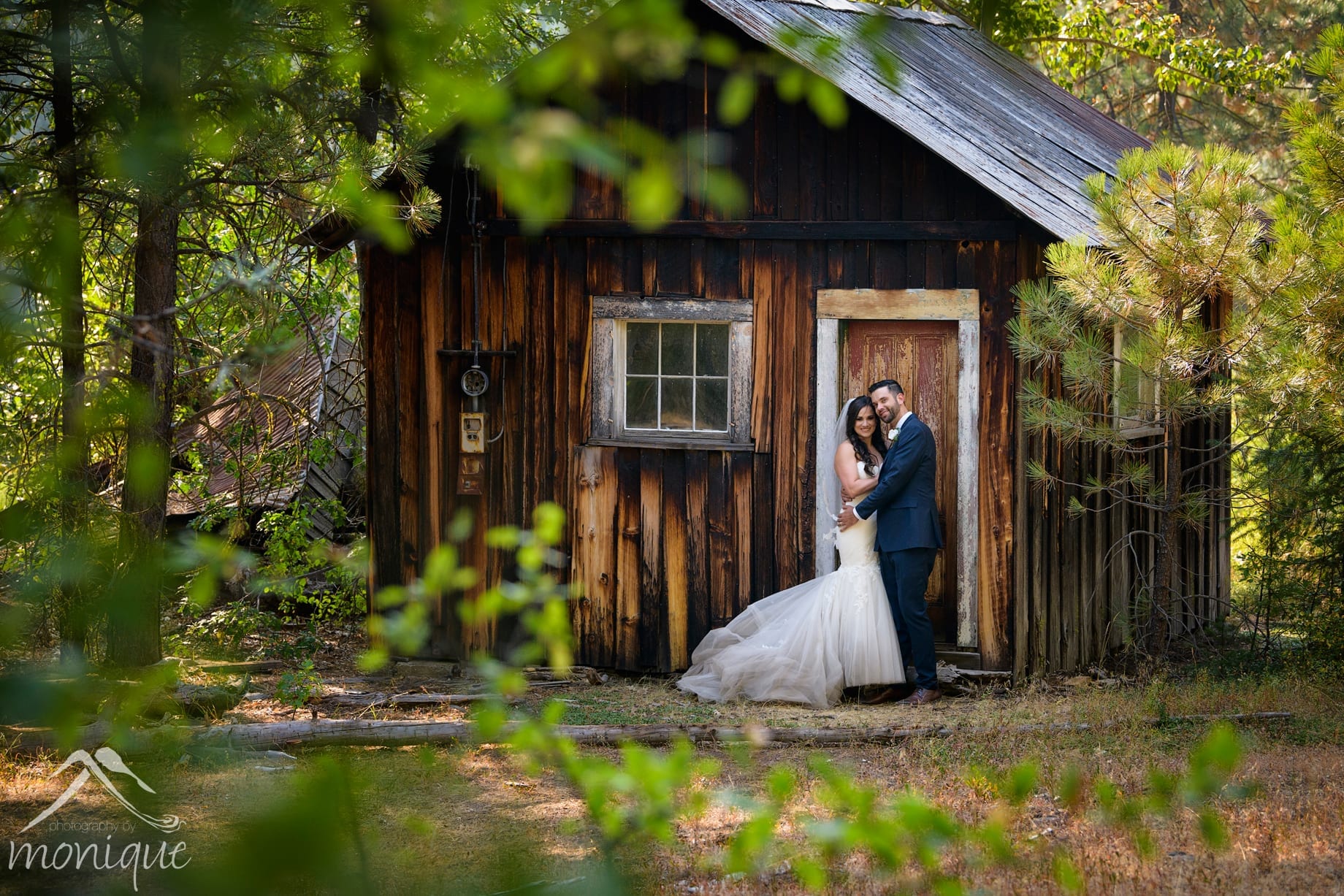 Twenty Mile House wedding photography with the bride and groom next to the historic miner's cabin
