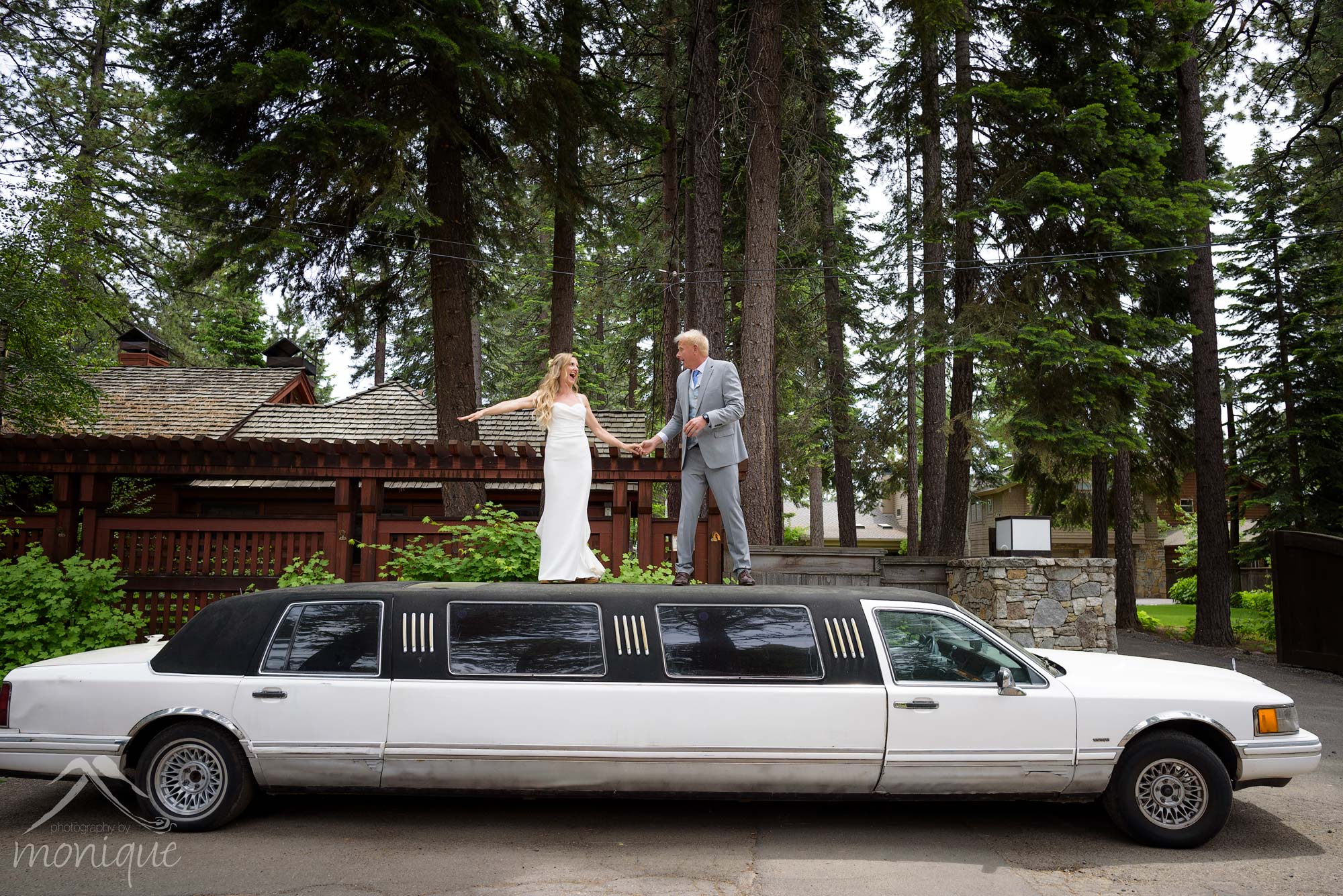 bride and groom dancing on top of limo