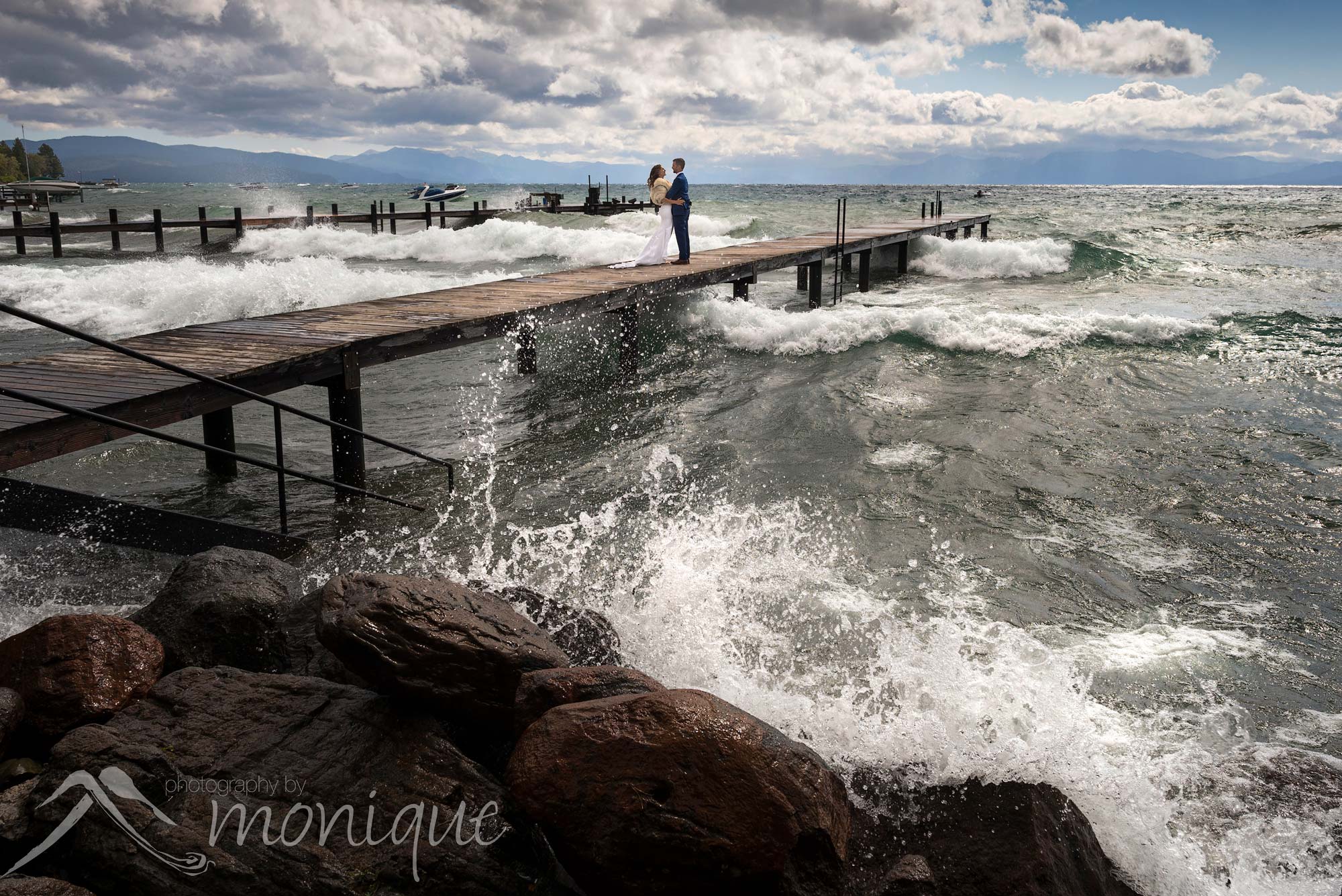 Lake Tahoe wedding photography with the bride and groom on a pier with waves crashing